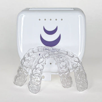 Clear dental aligner tray with a white device featuring a purple Lyla logo on a light gray background